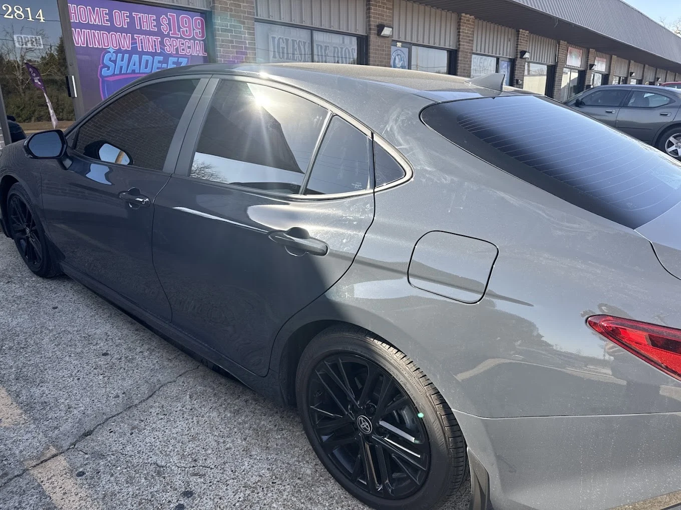 Gray Toyota Camry with dark window tint at the Shade-EZ storefront, ceramic vs carbon window tint in Bryan, TX